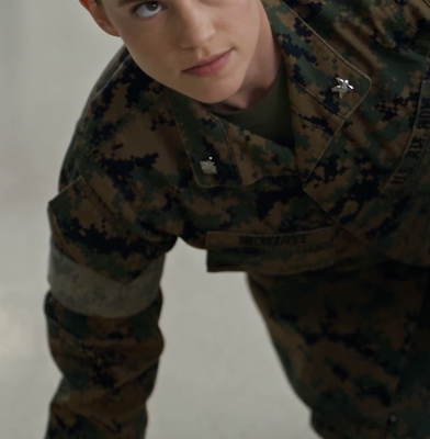 Female service member in camouflage looking up from the mess hall floor